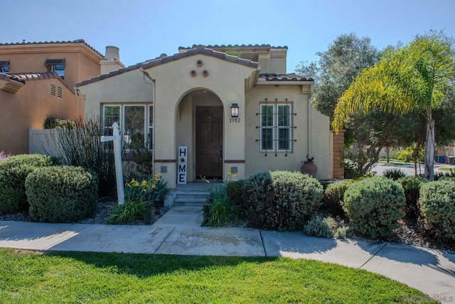 mediterranean / spanish home with a front yard