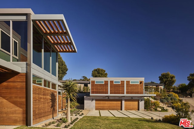 exterior space featuring a yard, a garage, and a pergola