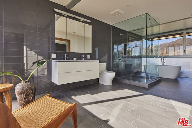 bathroom featuring a bath, a mountain view, toilet, vanity, and tile walls