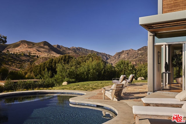 view of swimming pool featuring a patio area and a mountain view