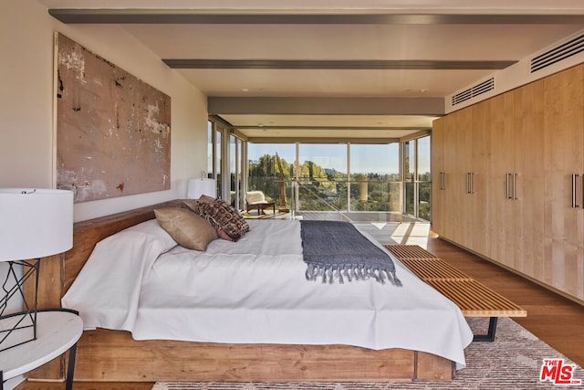 bedroom featuring hardwood / wood-style floors, access to outside, and wood walls