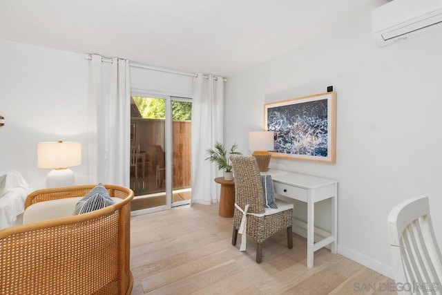 office with light hardwood / wood-style floors and a wall mounted air conditioner