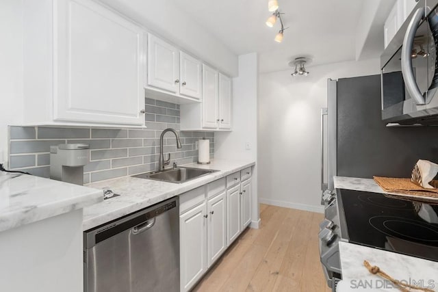 kitchen featuring sink, white cabinetry, light hardwood / wood-style flooring, and stainless steel appliances