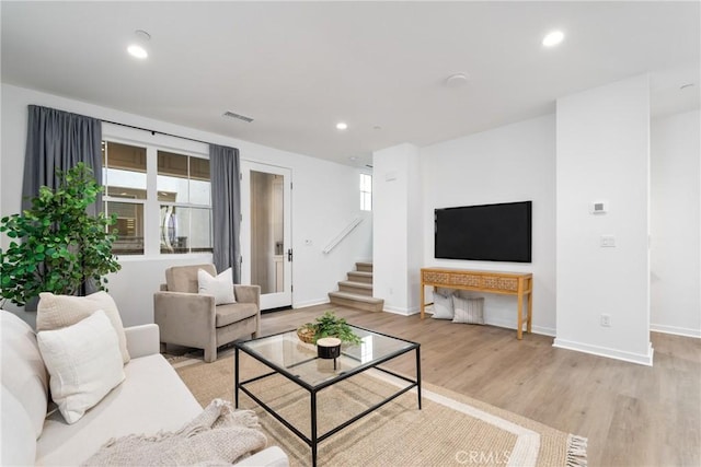 living room featuring recessed lighting, stairway, light wood-style floors, and visible vents