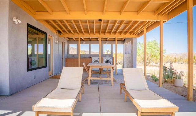 sunroom with washing machine and dryer, a wealth of natural light, and a mountain view