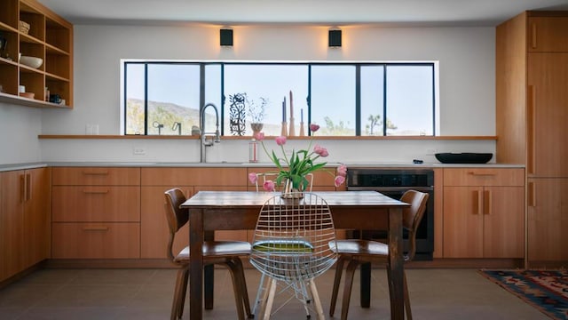 kitchen with a mountain view, sink, and light tile patterned floors