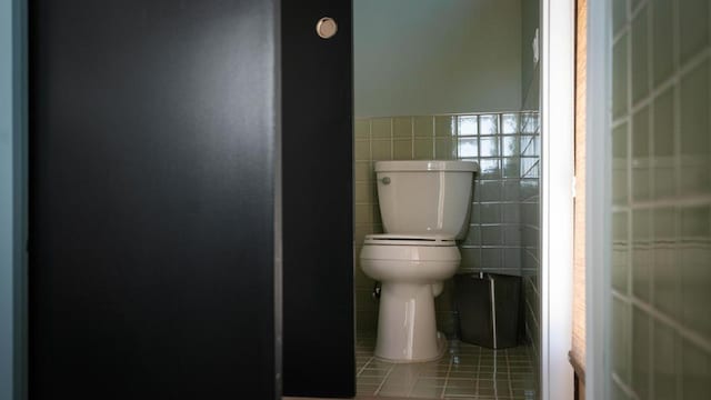 bathroom featuring tile patterned flooring, tile walls, and toilet