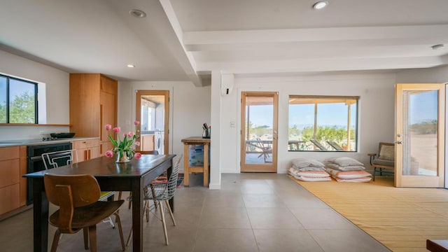 tiled dining space with washer / clothes dryer and a healthy amount of sunlight