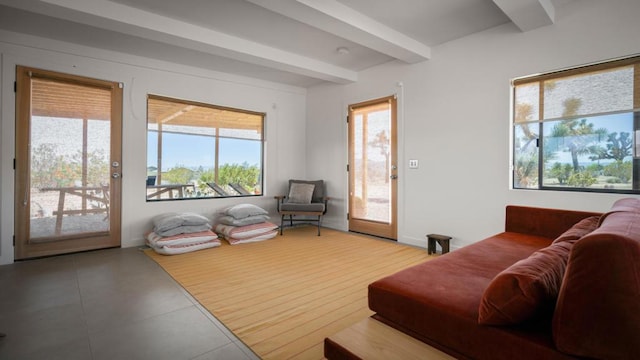 living room with beam ceiling and tile patterned flooring