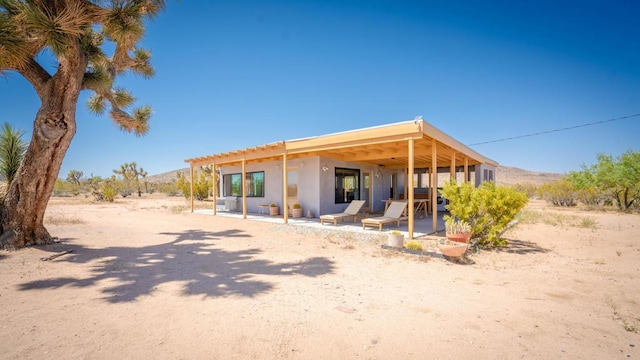 back of property with a patio area and a mountain view