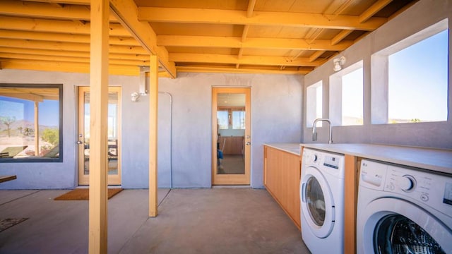 laundry room featuring washing machine and clothes dryer and a healthy amount of sunlight