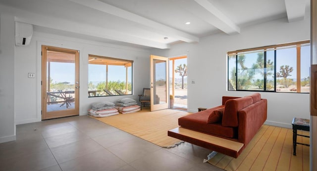 living room featuring beam ceiling, light tile patterned floors, and a wall mounted AC