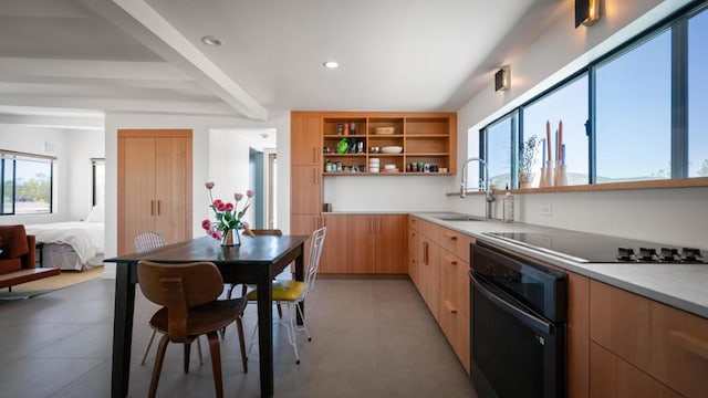 kitchen with black appliances, sink, beamed ceiling, and light brown cabinetry