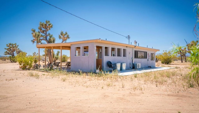 rear view of house featuring ac unit and a patio