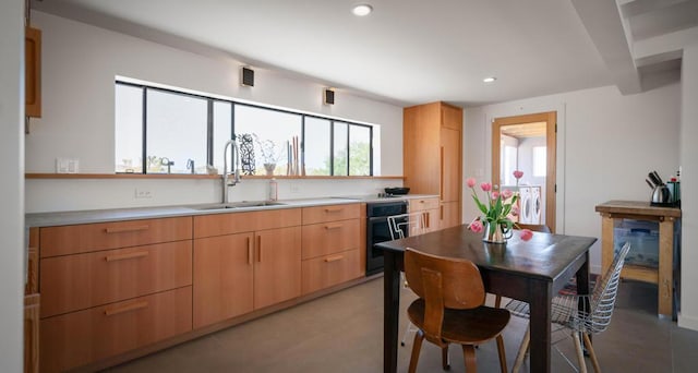 kitchen featuring light brown cabinetry, sink, and stainless steel oven