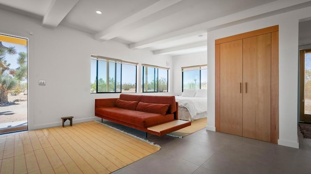 bedroom featuring beamed ceiling, access to outside, and a closet