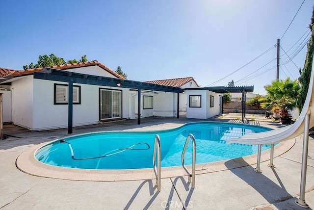 view of swimming pool with a patio and a water slide