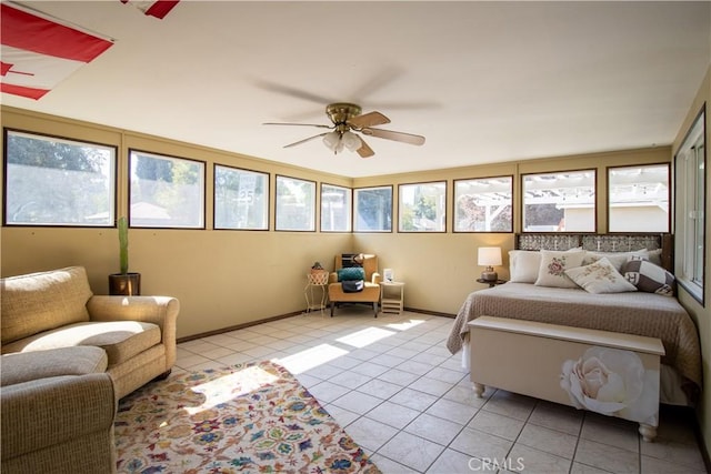 bedroom featuring ceiling fan, light tile patterned floors, and multiple windows