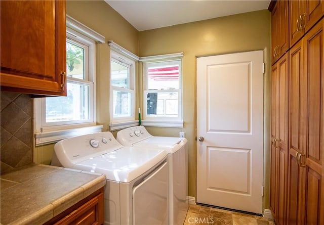 laundry room featuring cabinets and washing machine and clothes dryer