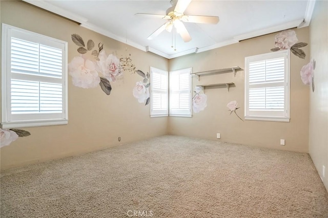 carpeted spare room with ornamental molding and a ceiling fan