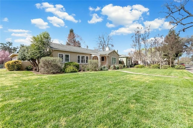 view of front of house with stucco siding and a front lawn