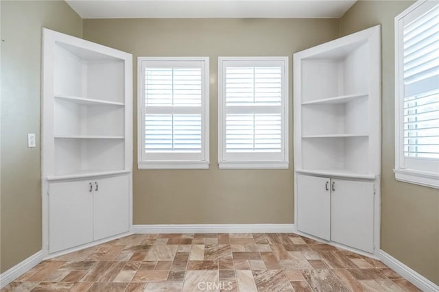 interior space with baseboards and stone finish floor