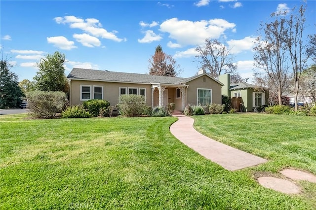 ranch-style home featuring a front yard and stucco siding