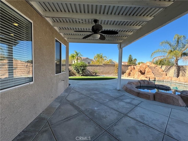 view of patio with ceiling fan and an in ground hot tub