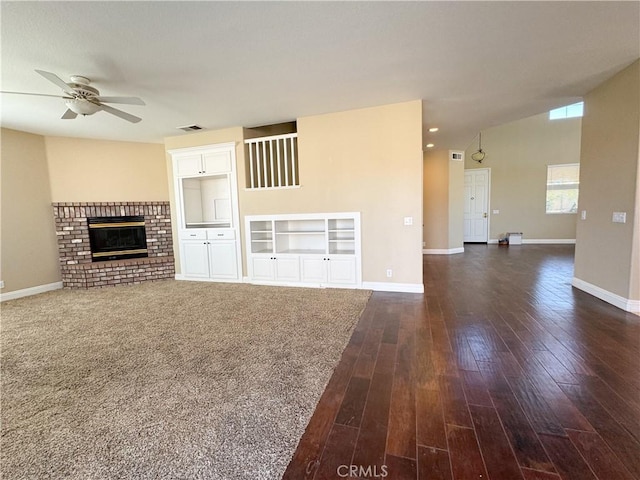 unfurnished living room with dark hardwood / wood-style floors, ceiling fan, lofted ceiling, and a brick fireplace