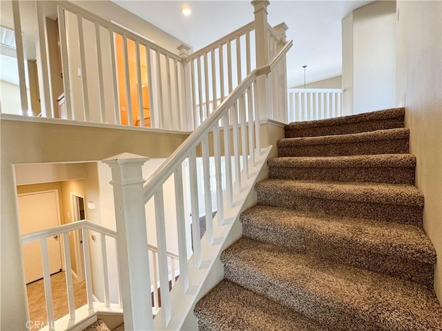 staircase featuring hardwood / wood-style floors and decorative columns