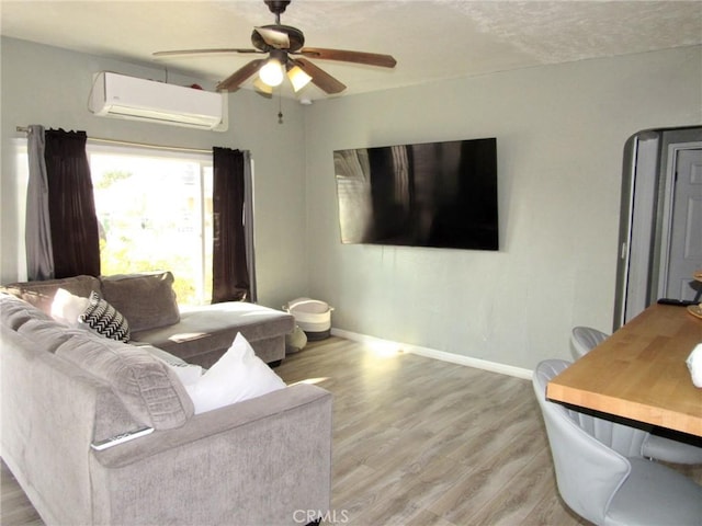 living room with hardwood / wood-style floors, a textured ceiling, a wall mounted AC, and ceiling fan