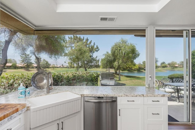 view of patio / terrace featuring sink, a water view, and an outdoor kitchen