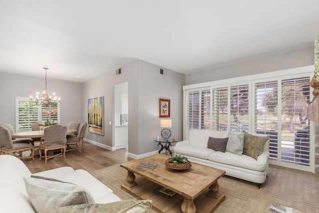 living room featuring light wood-type flooring and an inviting chandelier