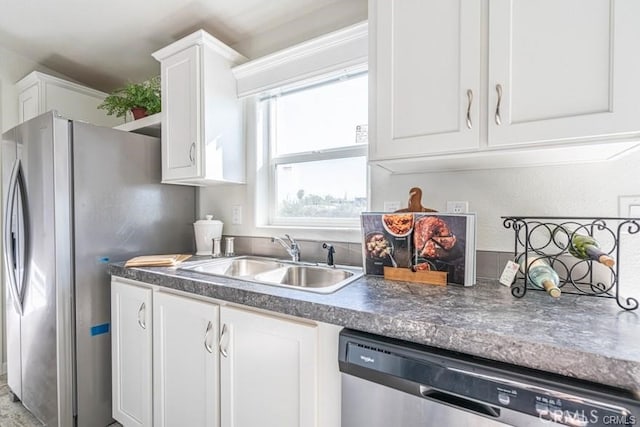 kitchen featuring white cabinets, appliances with stainless steel finishes, and sink