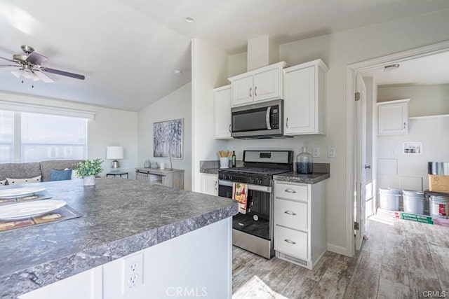 kitchen featuring ceiling fan, light hardwood / wood-style floors, lofted ceiling, white cabinets, and appliances with stainless steel finishes