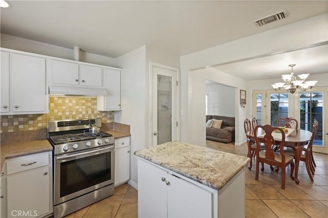 kitchen featuring decorative light fixtures, tasteful backsplash, a notable chandelier, white cabinetry, and stainless steel range with gas stovetop