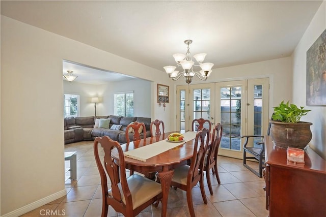 dining room with french doors, light tile patterned floors, and a notable chandelier