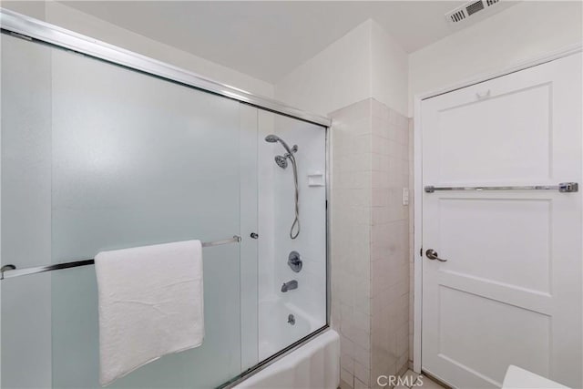 bathroom featuring bath / shower combo with glass door