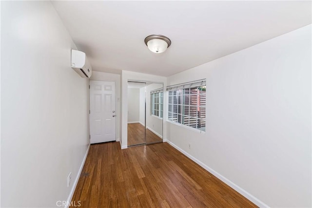 interior space with a wall unit AC, a closet, and hardwood / wood-style flooring