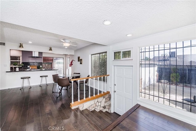 entryway featuring ceiling fan, dark wood-type flooring, and a textured ceiling