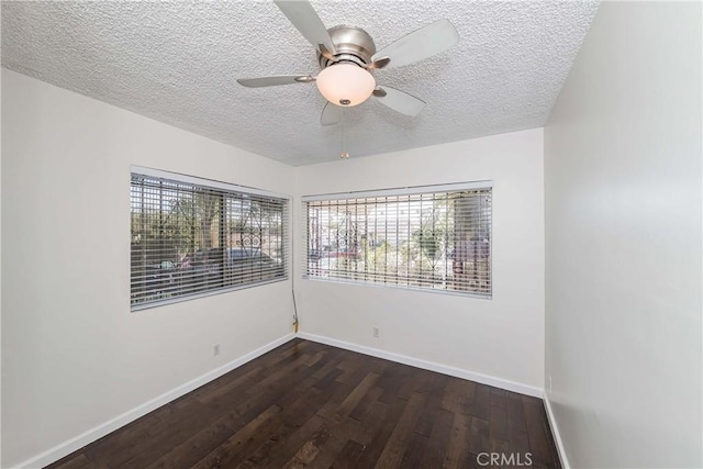 spare room featuring ceiling fan, dark wood-type flooring, and a textured ceiling