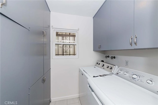 washroom featuring light tile patterned flooring, cabinets, and washing machine and clothes dryer