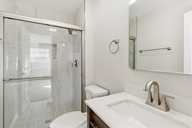 bathroom featuring toilet, an enclosed shower, and vanity