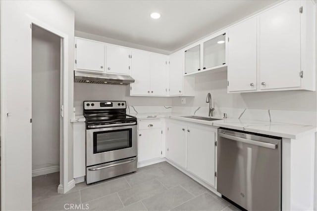 kitchen featuring light stone counters, white cabinets, appliances with stainless steel finishes, and sink