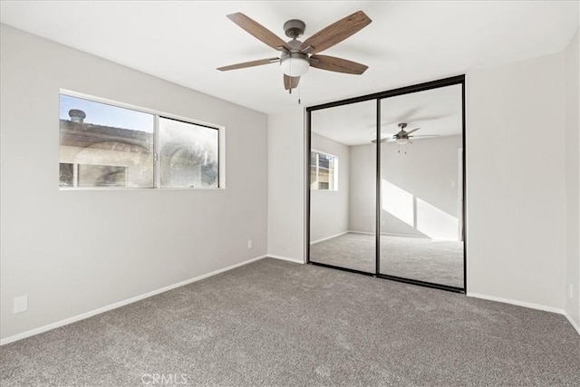 unfurnished bedroom featuring ceiling fan, a closet, and carpet