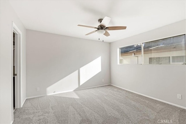 spare room featuring light colored carpet and ceiling fan