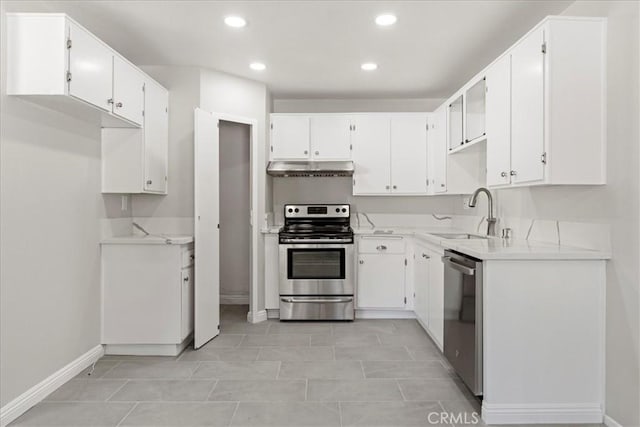 kitchen with appliances with stainless steel finishes, white cabinets, light tile patterned flooring, and sink