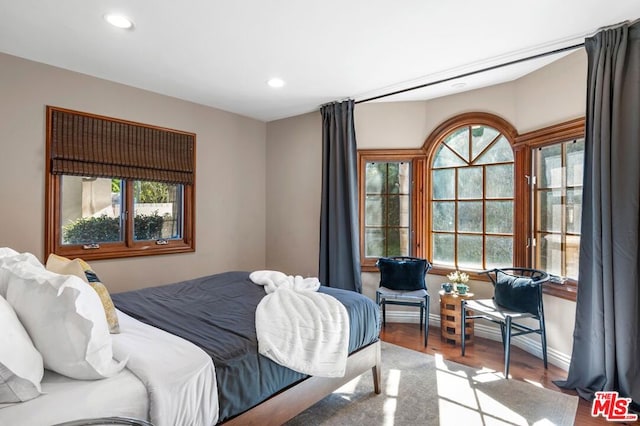 bedroom with light hardwood / wood-style floors and multiple windows