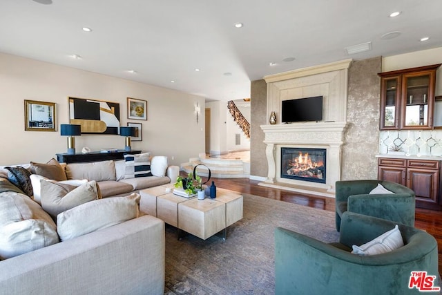 living room with a fireplace and dark wood-type flooring