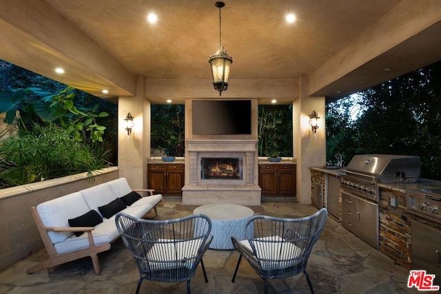 view of patio / terrace featuring an outdoor living space with a fireplace, area for grilling, sink, and an outdoor kitchen